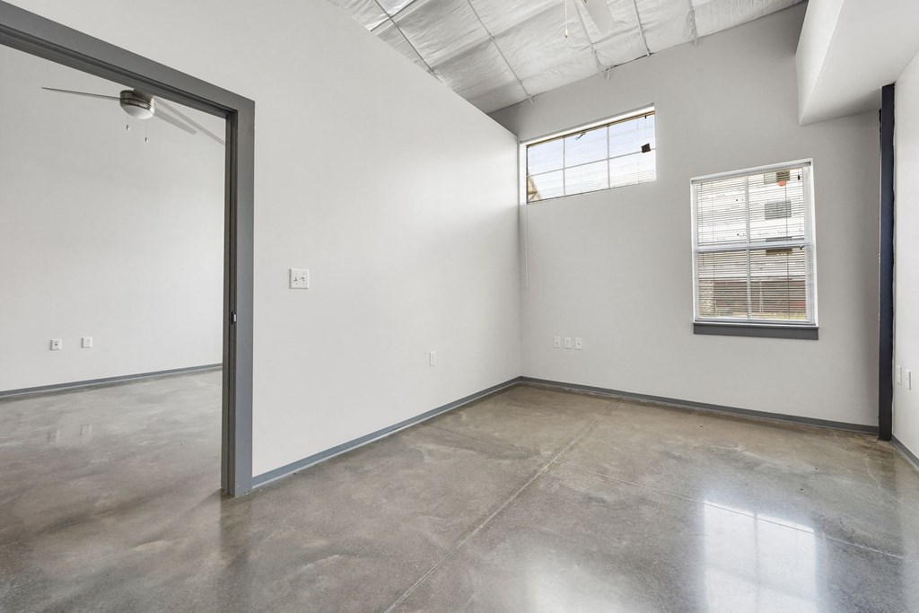 the interior of an empty room with white walls and a window