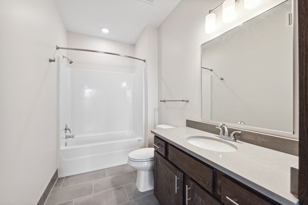 a bathroom with a shower sink and toilet and a mirror
