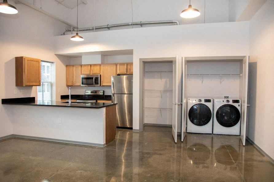 a laundry room with a washer and dryer and a kitchen