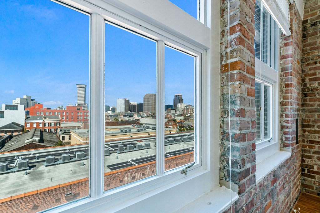 the view of the city from a window in a brick building