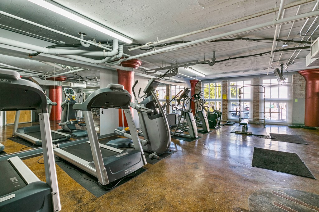 a gym with treadmills and other exercise equipment in a loft