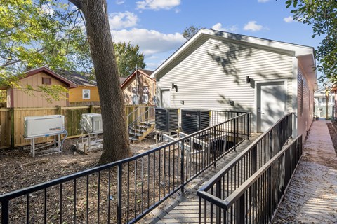 A house with a white fence and a black railing.
