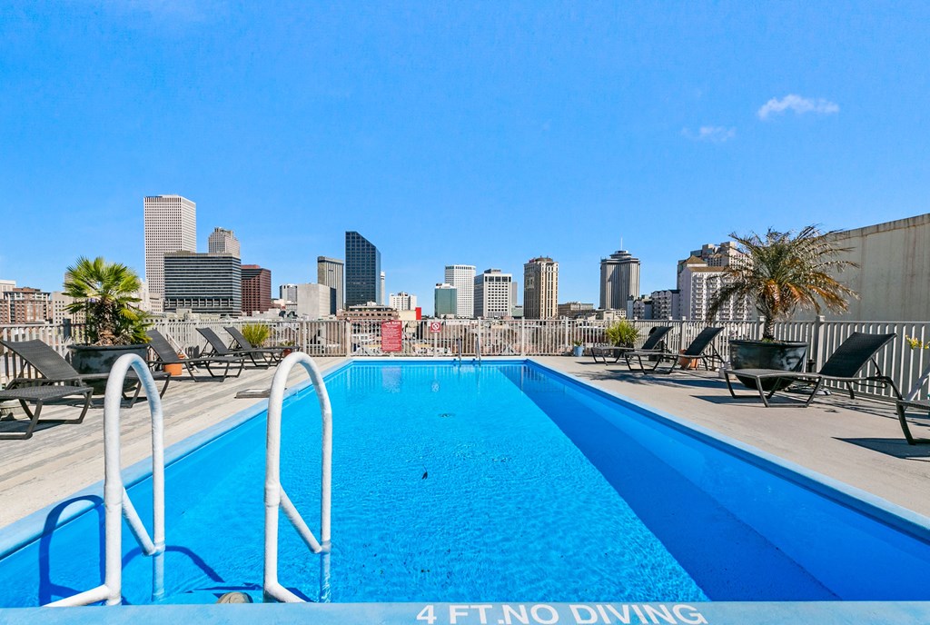 a swimming pool with a city skyline in the background