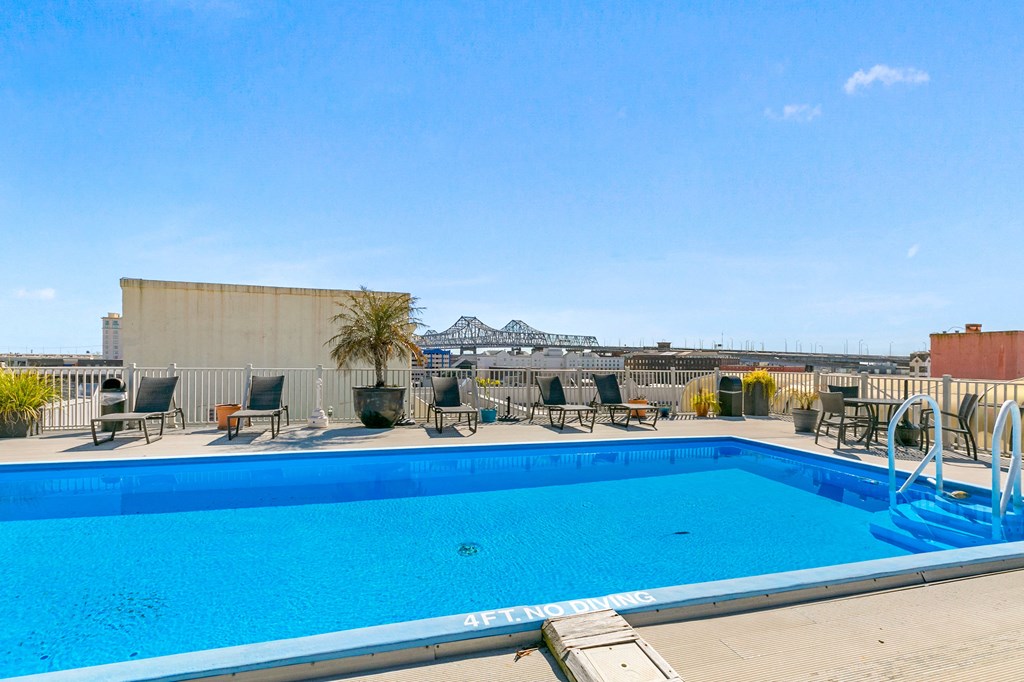 the pool at the top of a building with a blue pool