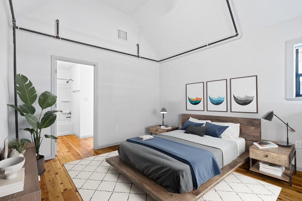 a bedroom with white walls and a bed with blue pillows