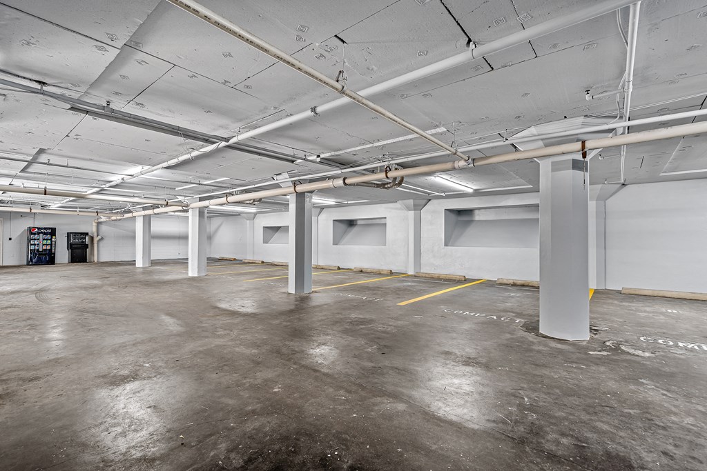 the interior of a parking garage with white walls and concrete floors