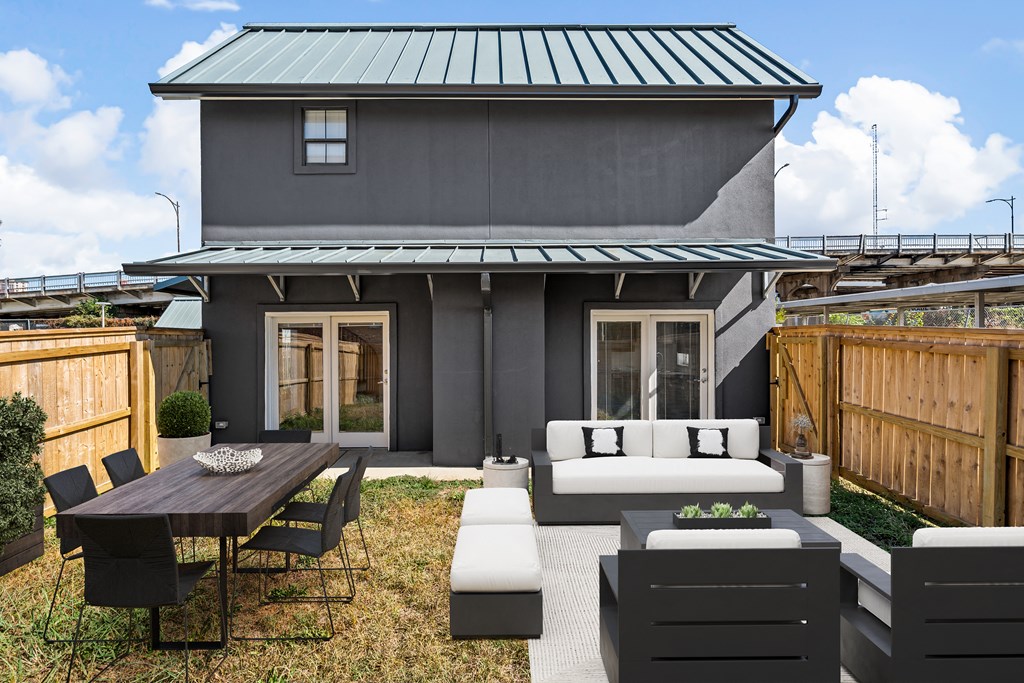 a patio with a couch and a table in front of a house