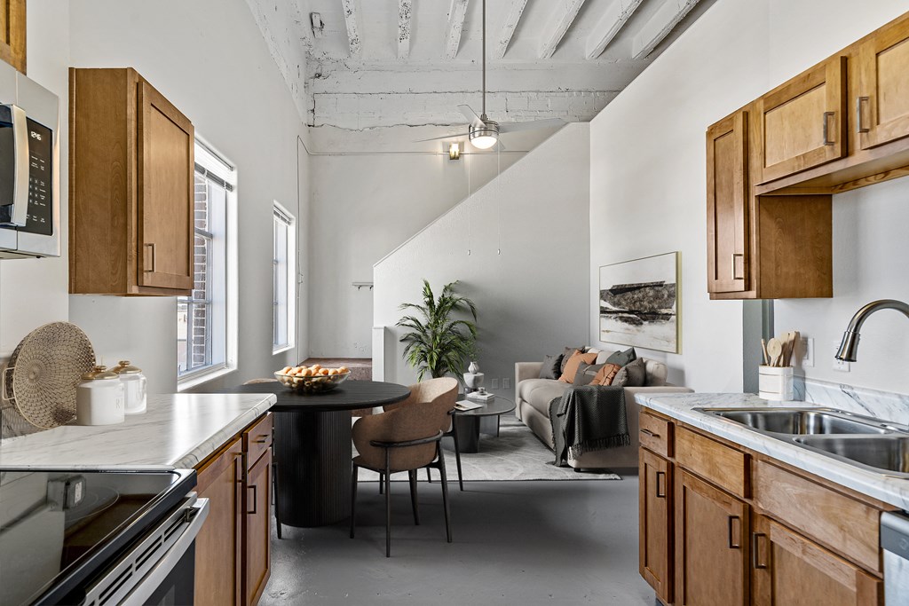 a kitchen with a sink and a table and a living room with a couch