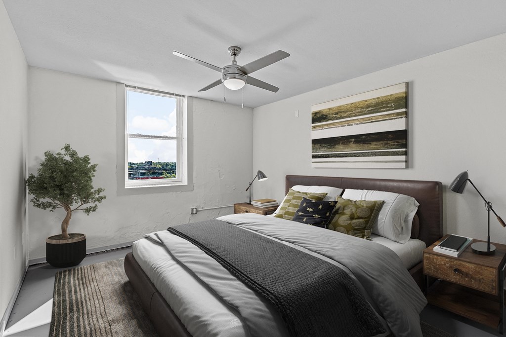 a bedroom with a bed and a ceiling fan