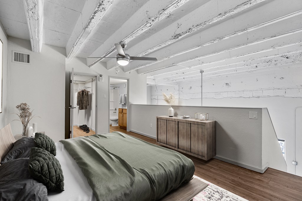 a bedroom with a bed and a dresser and a bathroom