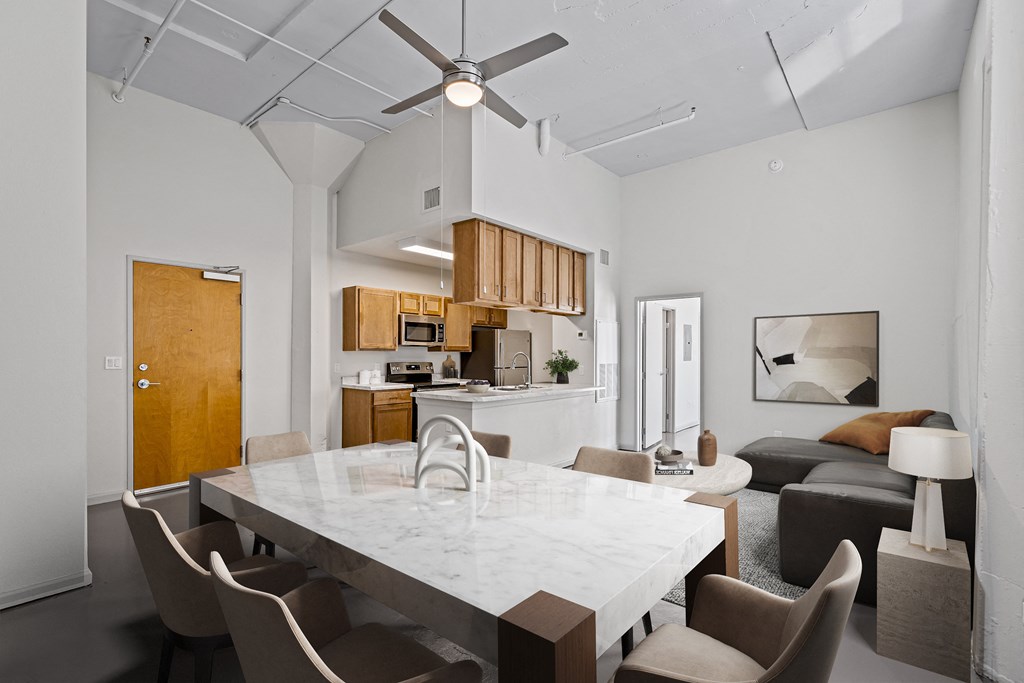 a living room and dining room with a marble table and a kitchen