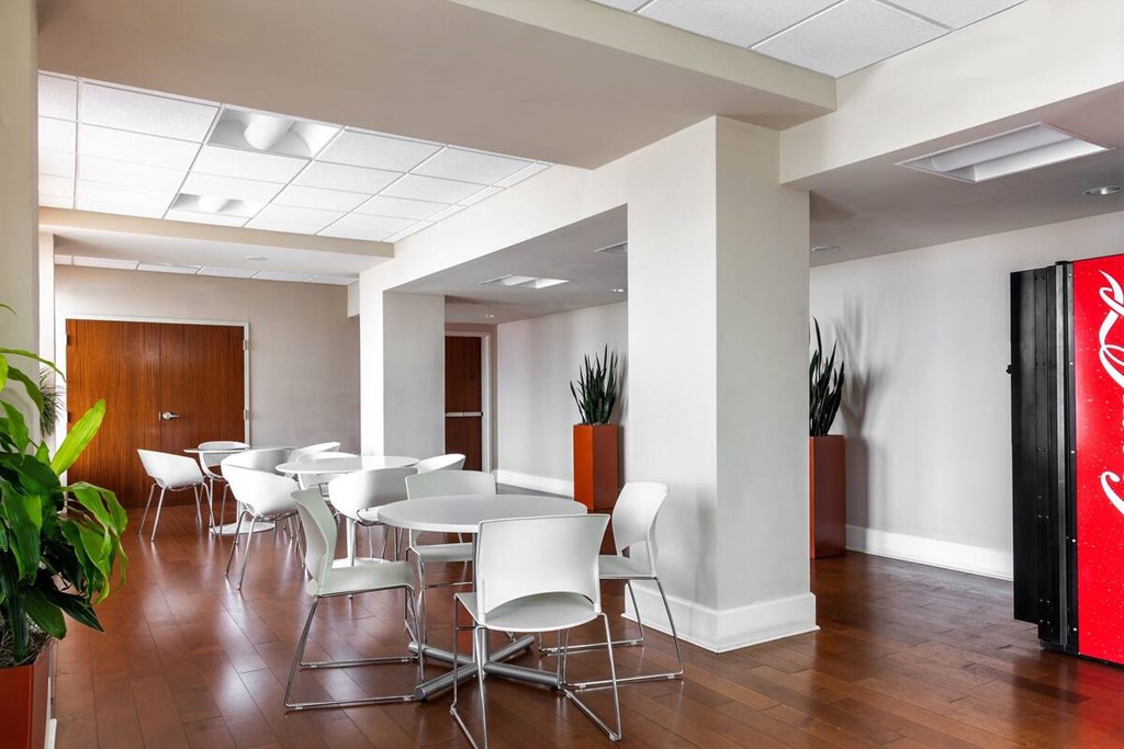 A conference room with white chairs and a red Coca-Cola sign.