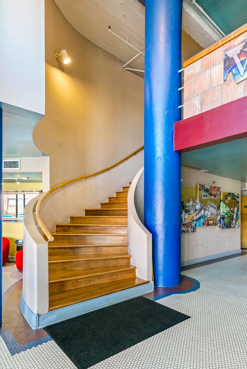 a spiral staircase in a building with a blue pole
