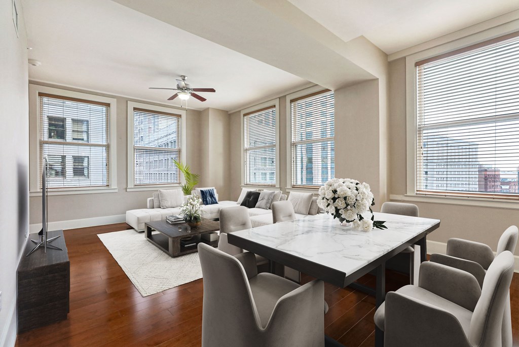 a living room with a table and chairs and windows