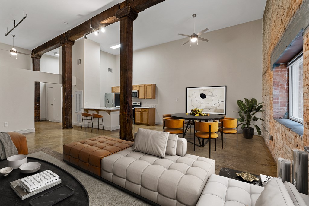 a living room with a large white couch and a table and chairs