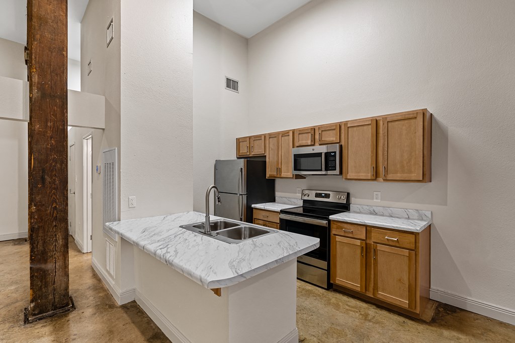a kitchen with an island and a sink and a refrigerator