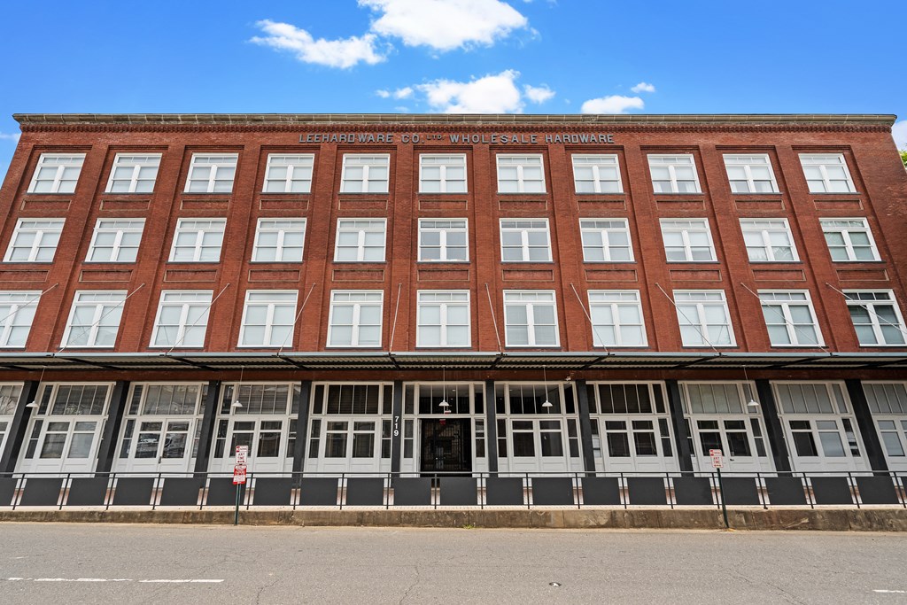 a large brick building with many windows and a street in front
