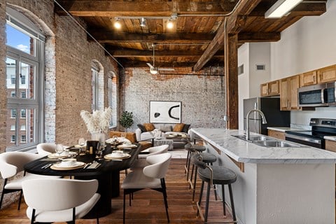 a kitchen and living room in a loft with a table and chairs