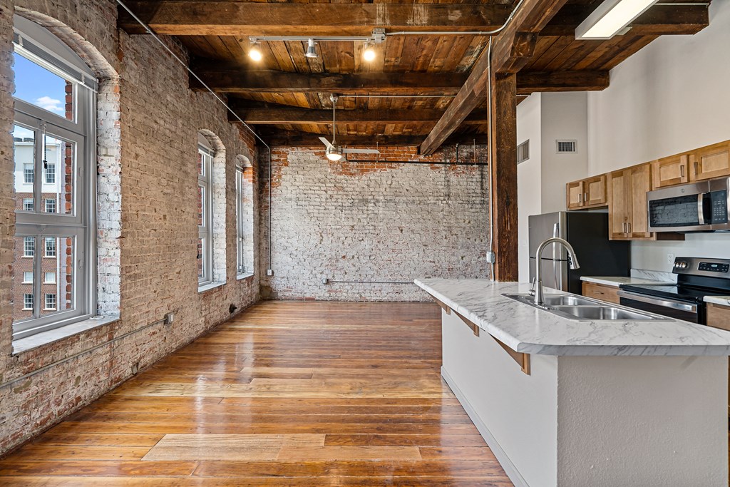 a kitchen with a large island and a exposed brick wall