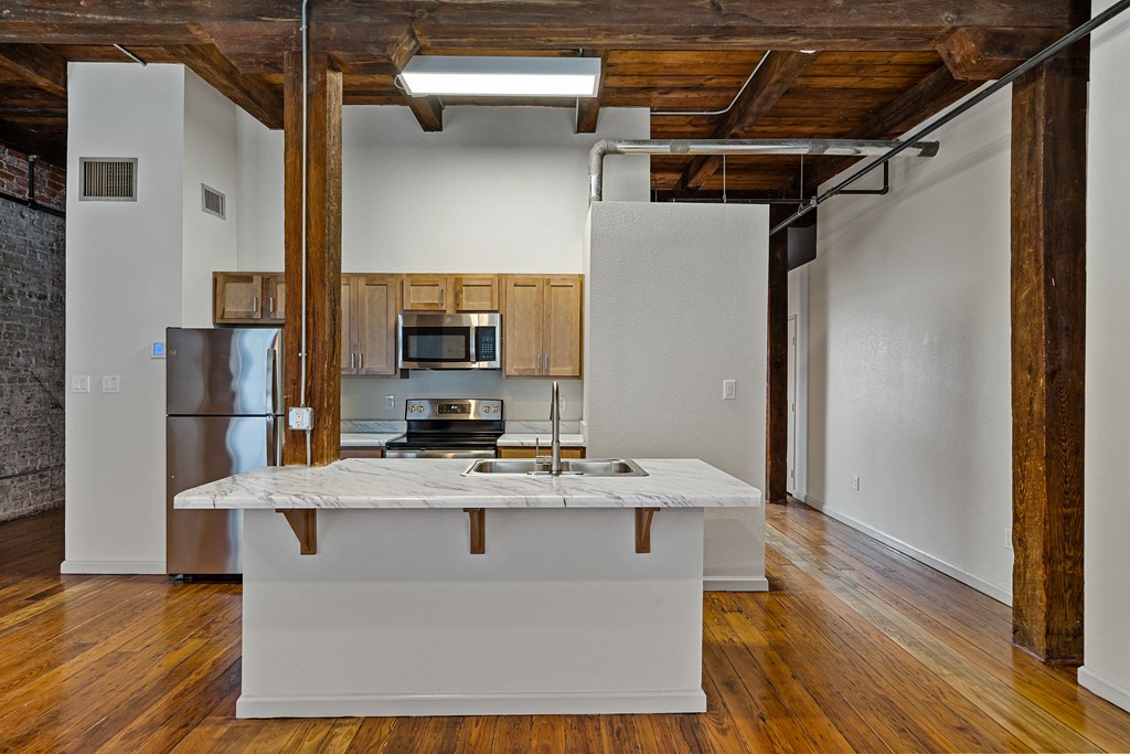 a kitchen with a white island and a stainless steel refrigerator
