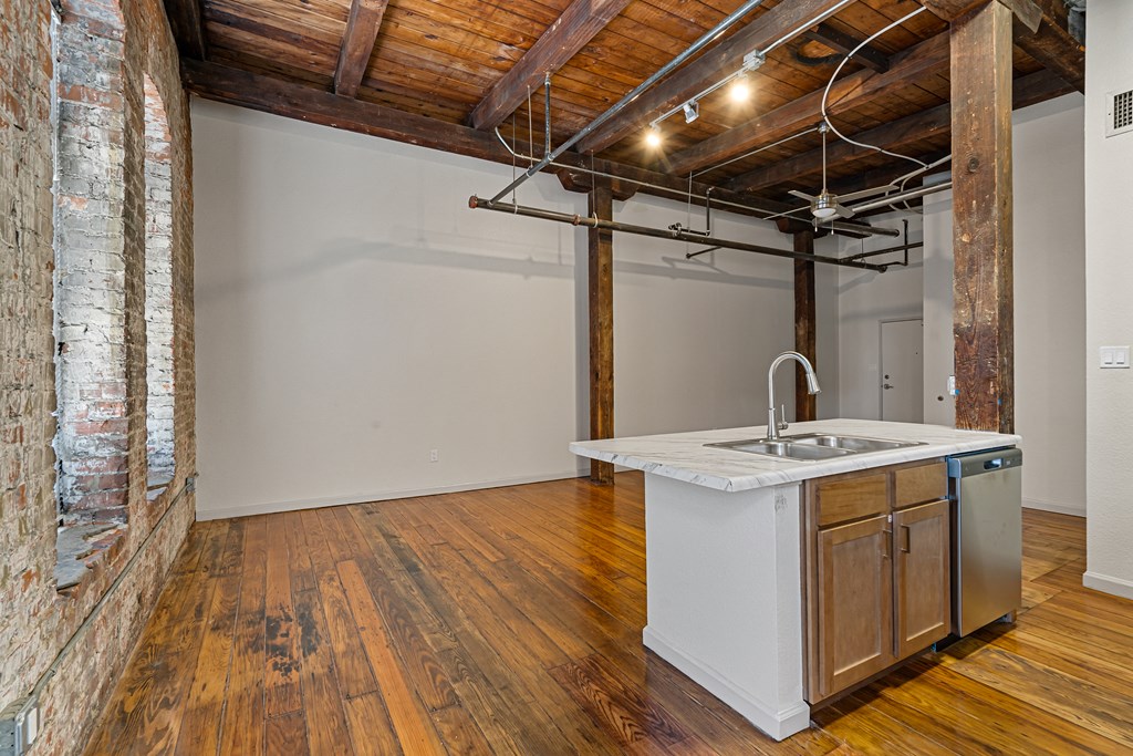 a kitchen with an island in a room with a exposed brick wall