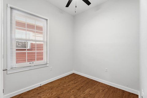 A room with a window and a ceiling fan.