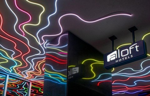 A colorful neon sign for Aloft Hotels.