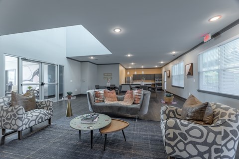 A spacious waiting room with grey couches and pillows.