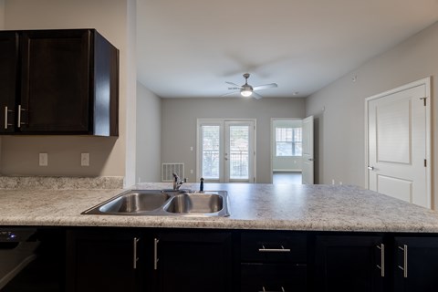 A kitchen with a sink and a ceiling fan.
