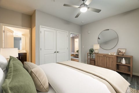 A bedroom with a large bed and a ceiling fan.