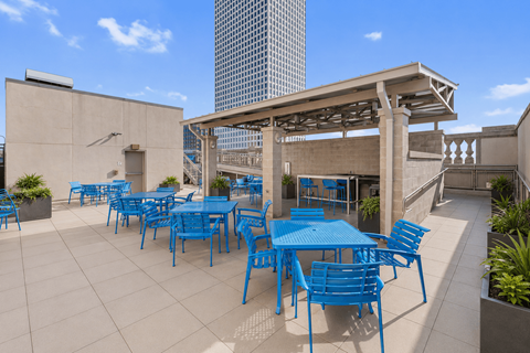 A patio with blue chairs and tables.