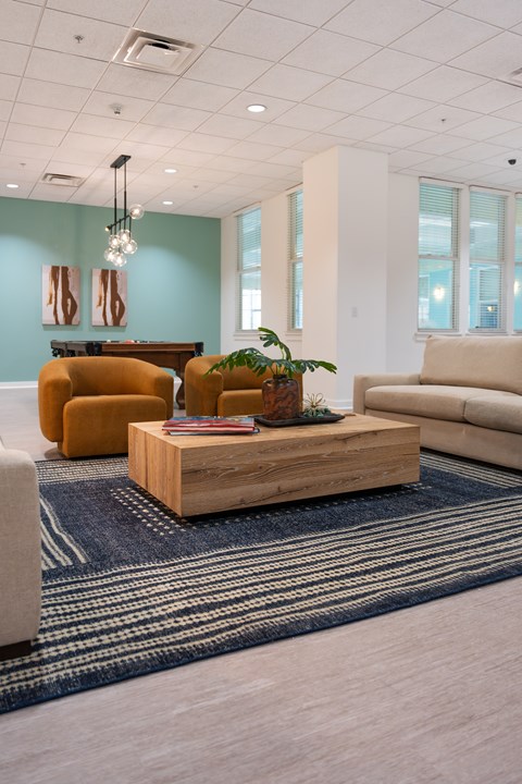 A living room with a wooden coffee table and a blue rug.