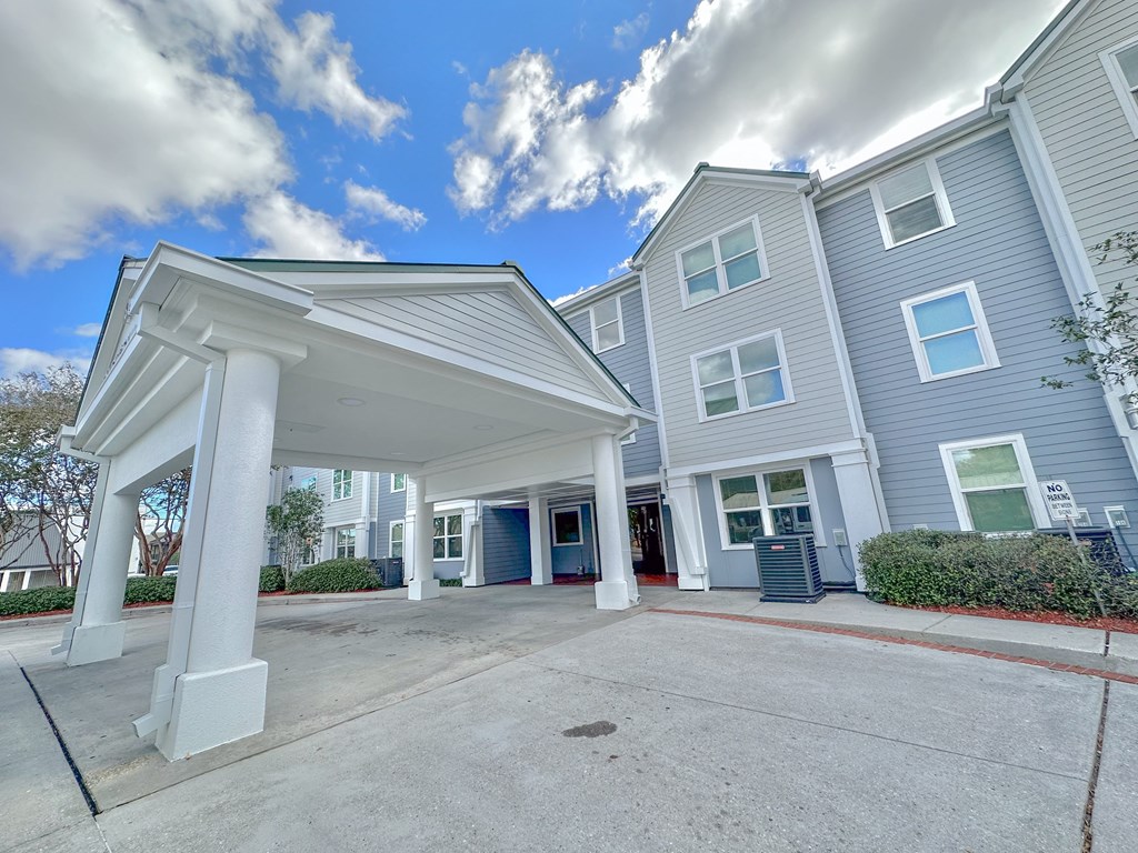 the entrance to a building with white pillars and a driveway