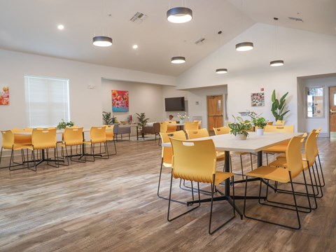 a conference room with yellow chairs and a white table