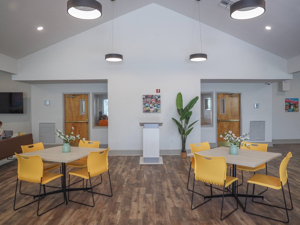 a dining room with yellow chairs and a table with chairs