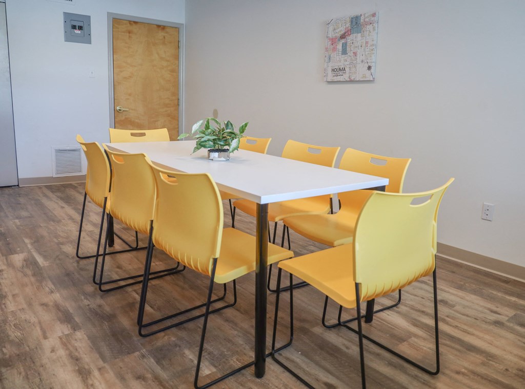 a dining table with yellow chairs in a room with wooden floors