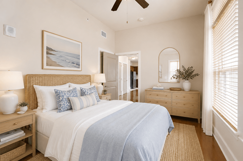 A bedroom with a large bed and a painting on the wall.