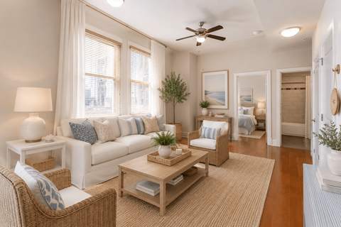 A well-lit living room with a sofa, armchair, and coffee table.