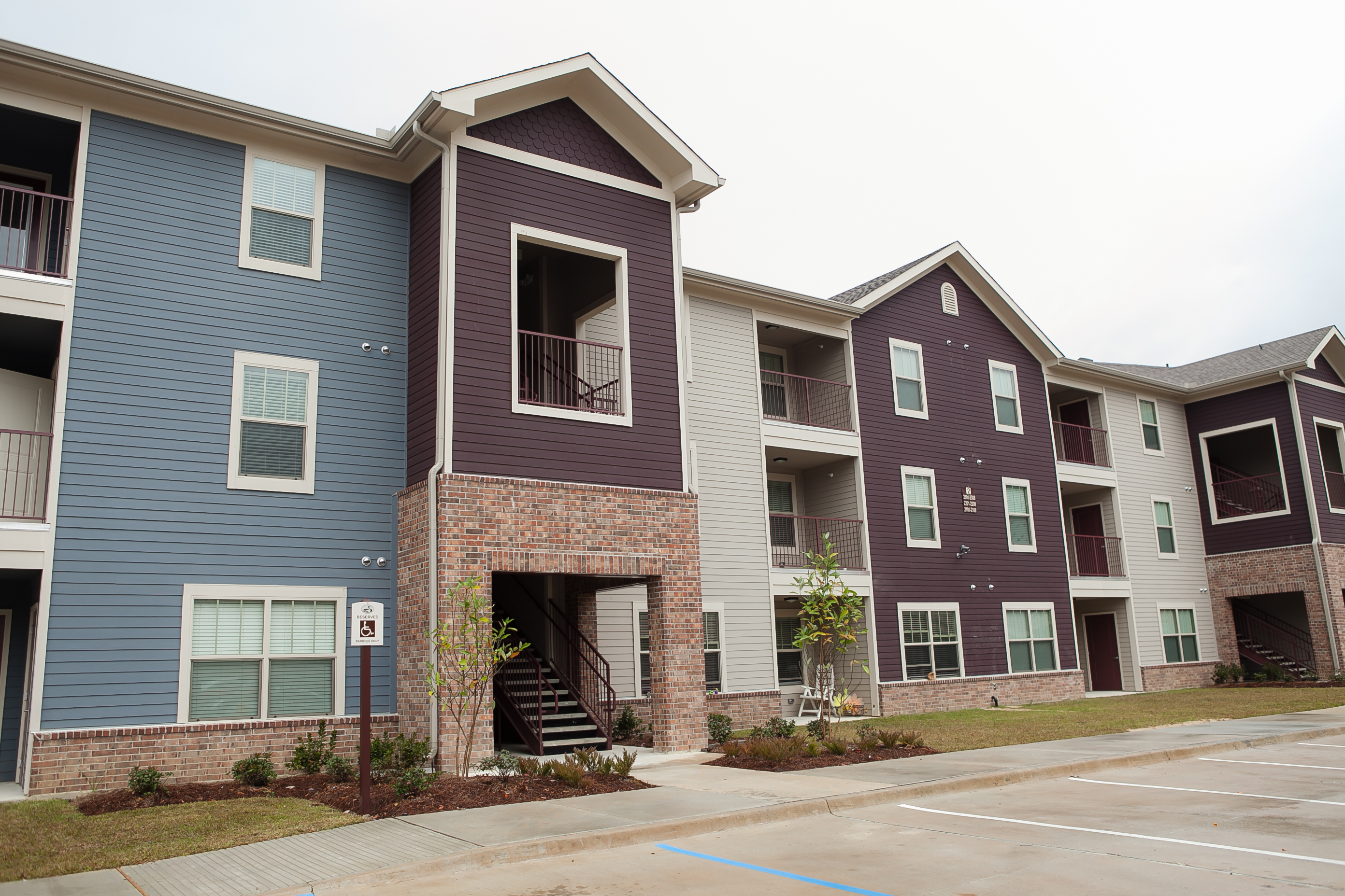 Apartment buildings with a parking lot in front.
