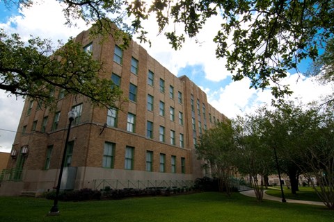 A large building with a green lawn in front.