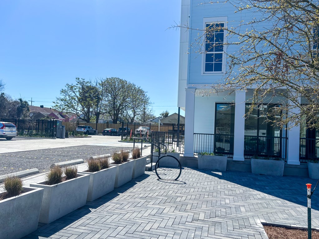 A white building with a black gate and a white fence.