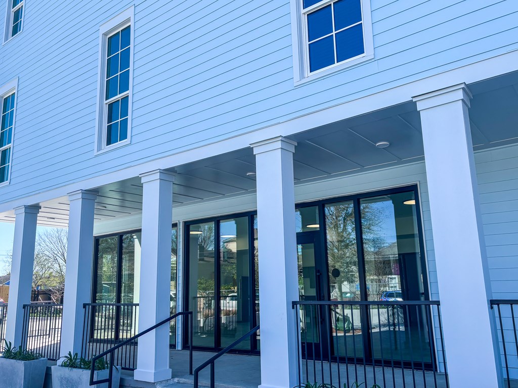 A white building with blue trim and a black railing.
