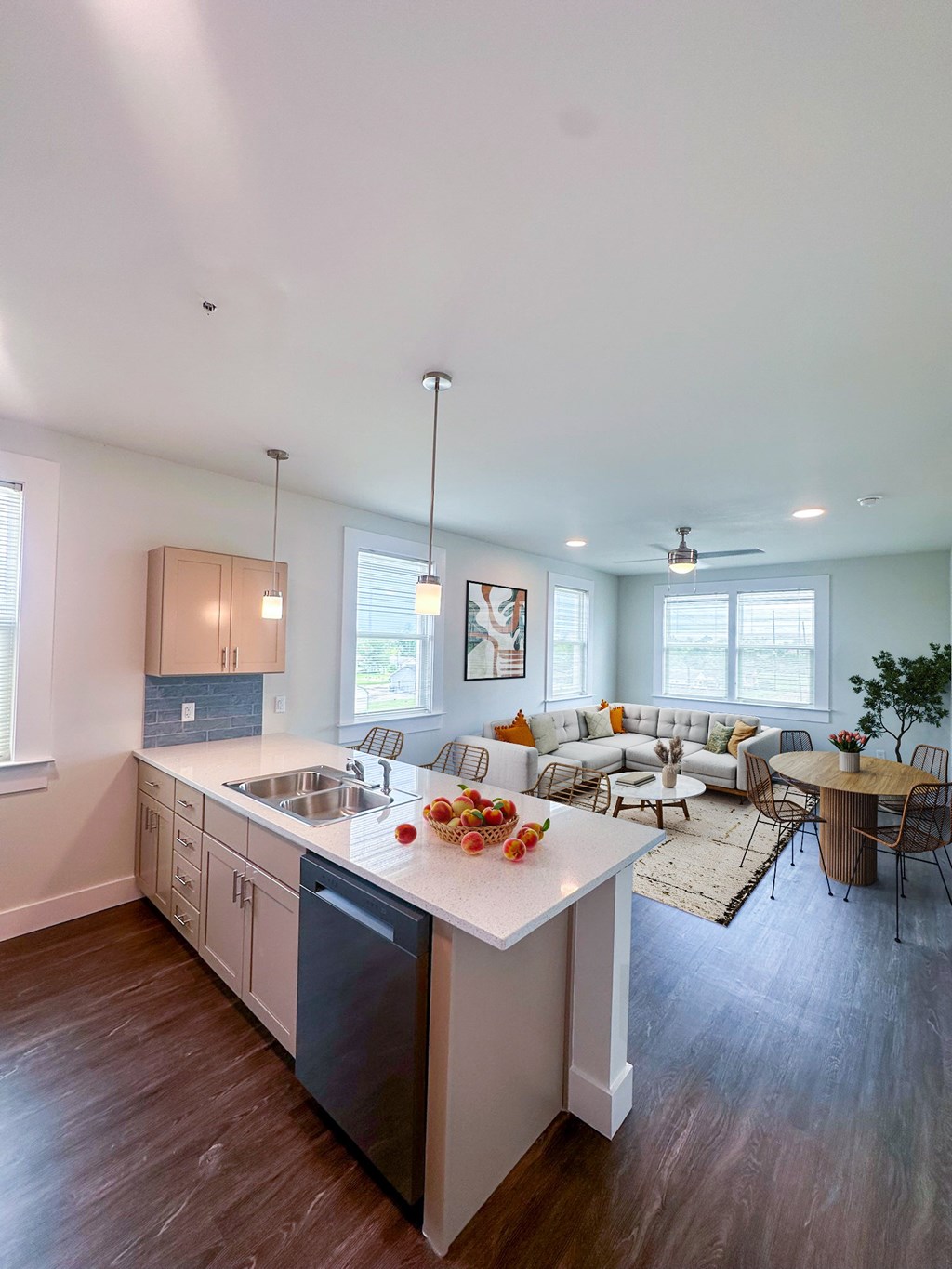 A modern kitchen with a white island and wooden floors.