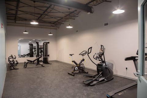 a gym with exercise equipment and lights in the ceiling