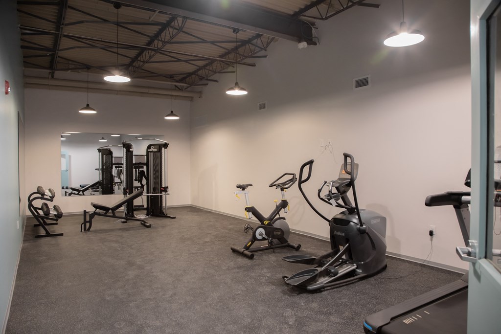 a gym with exercise equipment and lights in the ceiling