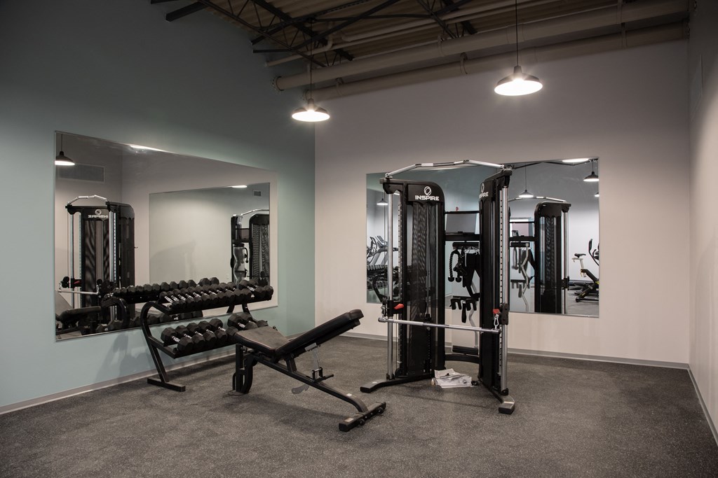 a fitness room with exercise equipment and mirrors in a studio space