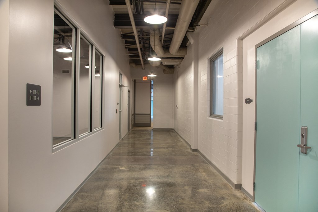 a hallway in a building with white walls and glass doors