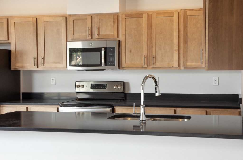 a kitchen with wooden cabinets and a sink and a microwave