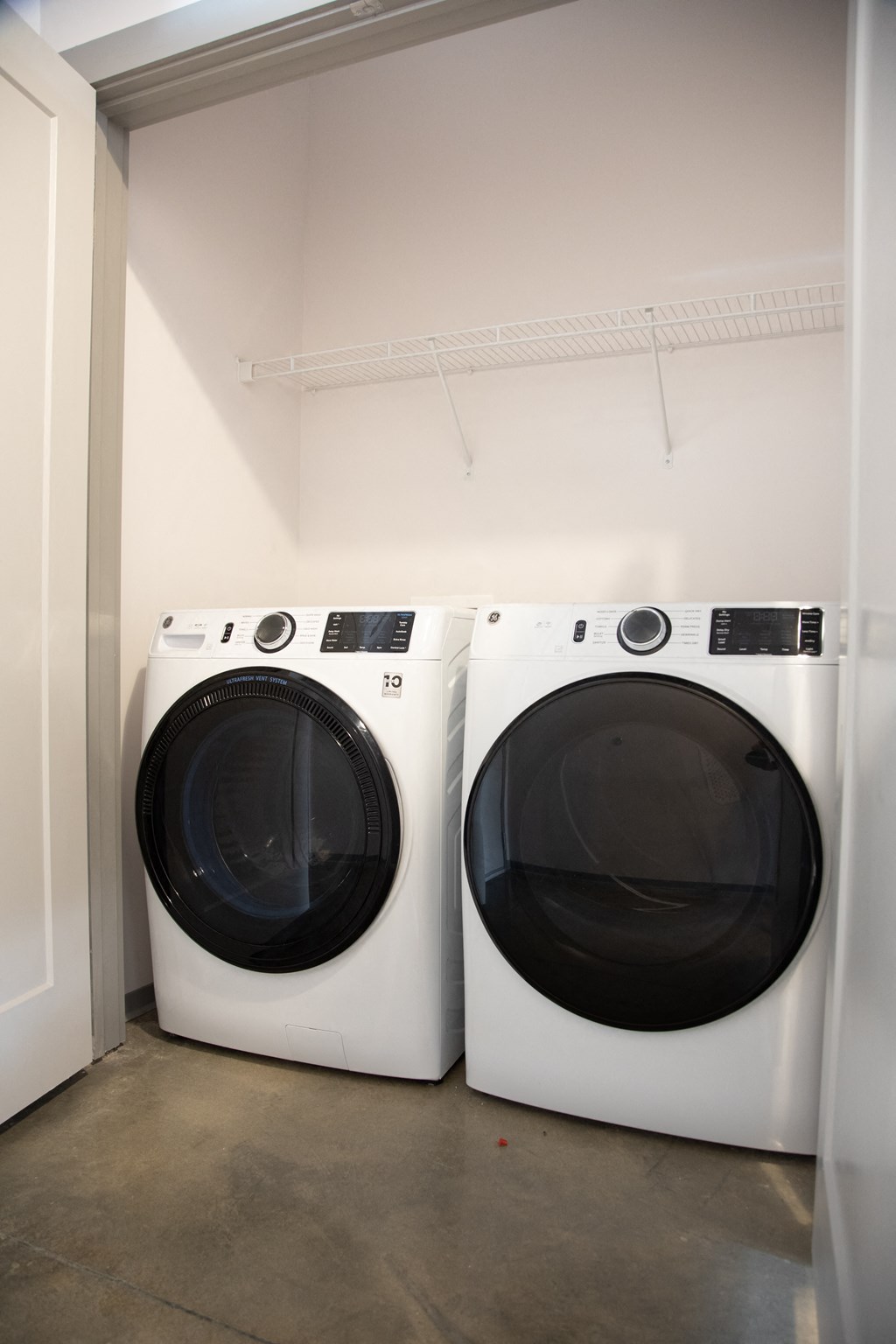 two washing machines in a white laundry room