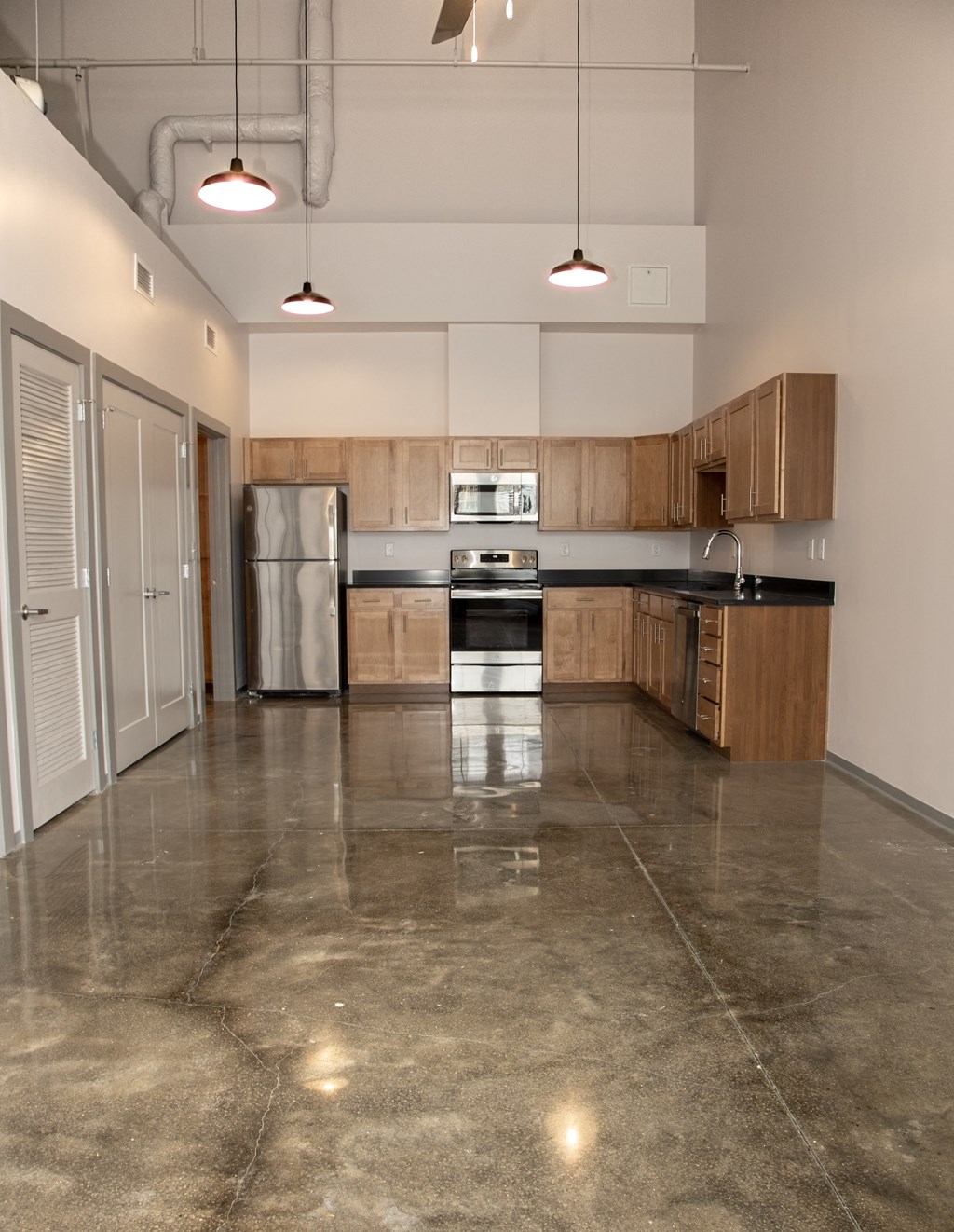an empty kitchen with stainless steel appliances and wooden cabinets